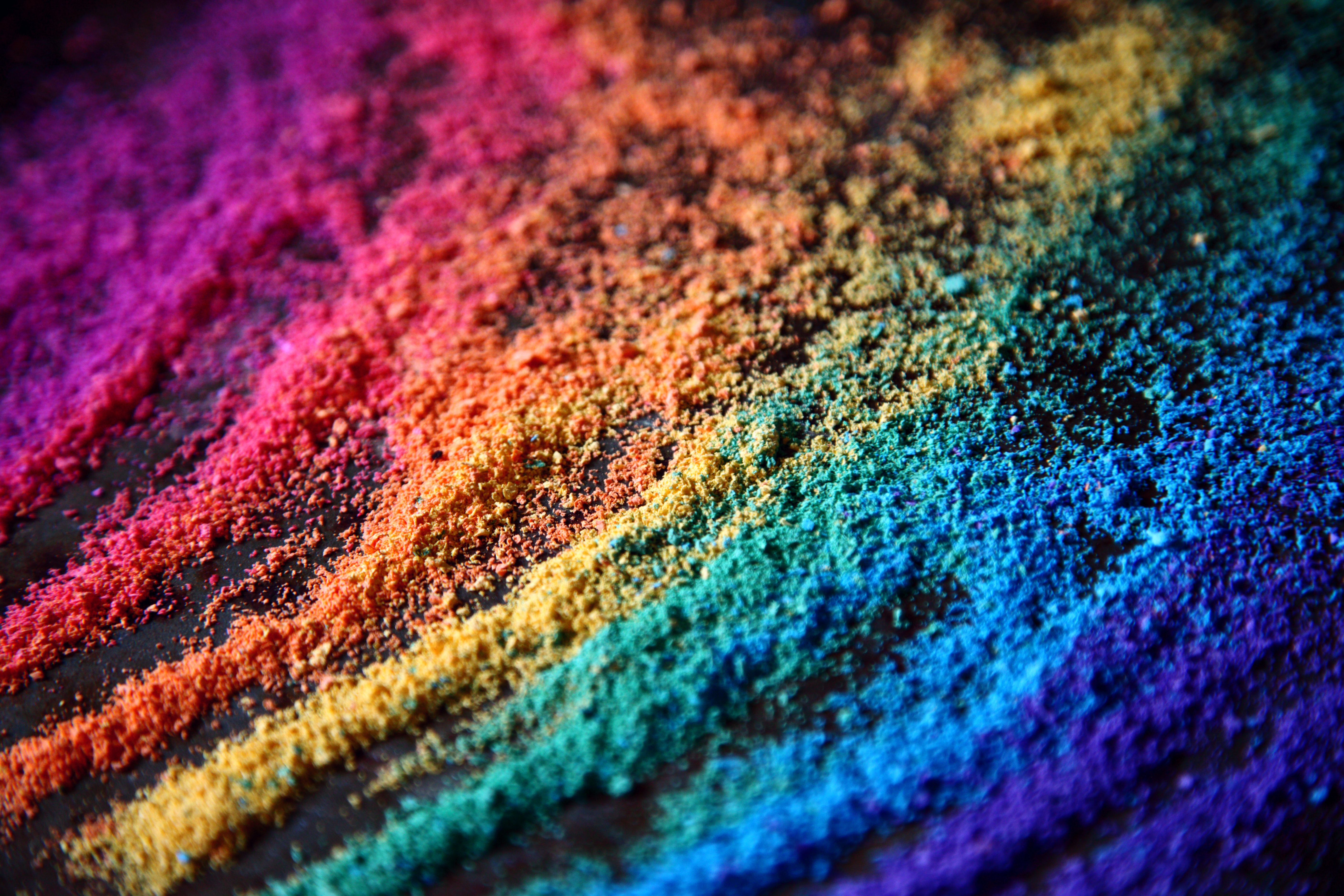 A horizontal image of chalk layer so heavily on the ground, it is leaving a rainbow trail of chunky chalk dust from the top right hand corner to the bottom left hand corner. 