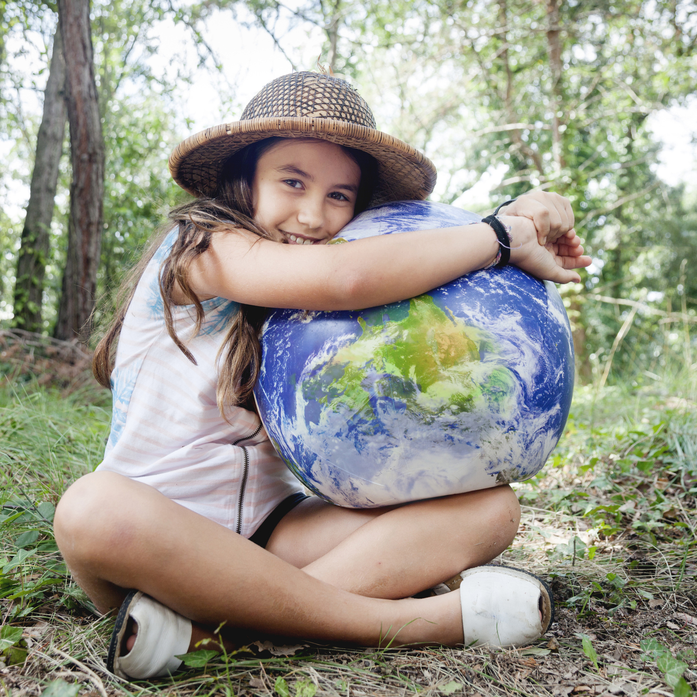 Child in forest holding Earth in their lap