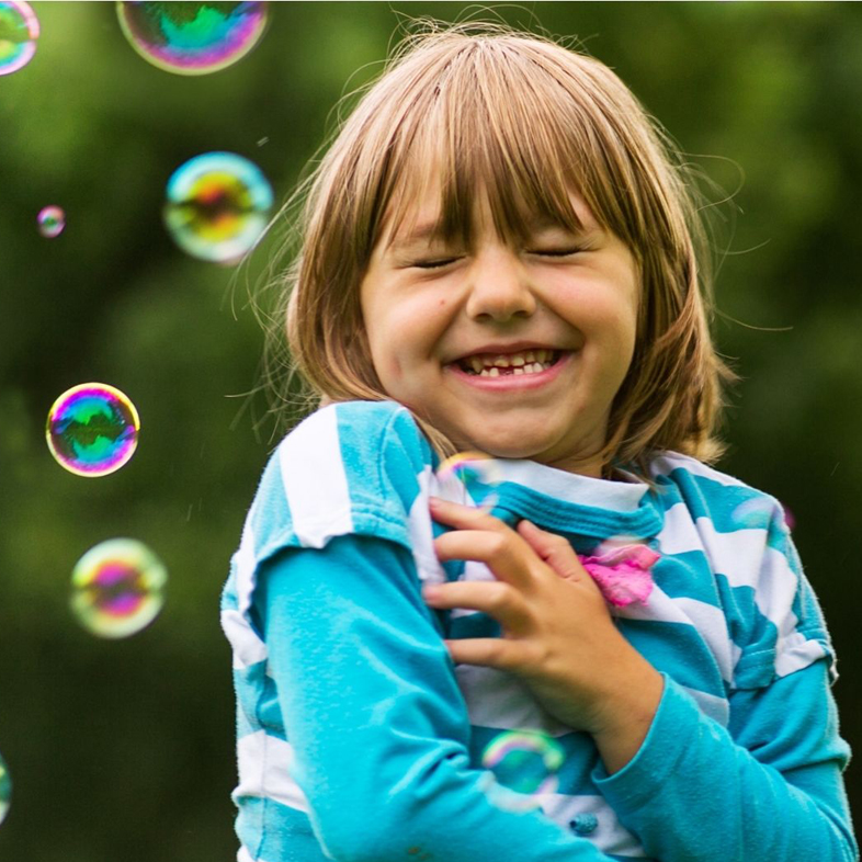 Young girl playing in bubbles