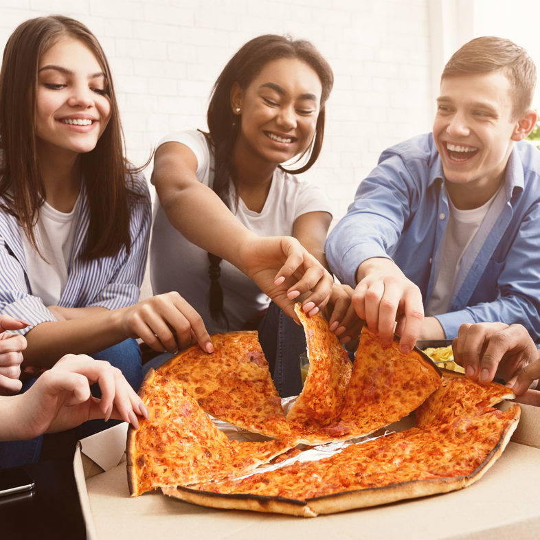 College age students eating pizza