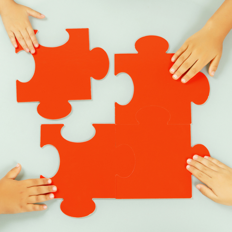 hands assembling puzzle