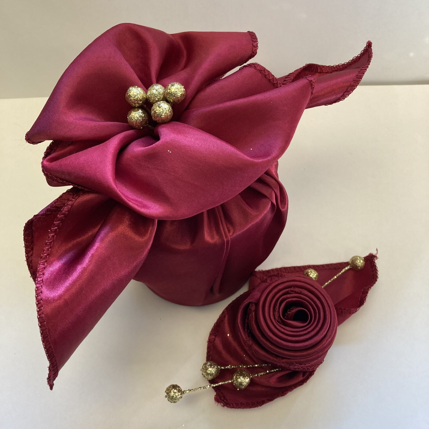 Fabric wrapped gift and rosette folded napkin