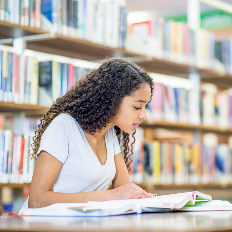 Teen studying at library table