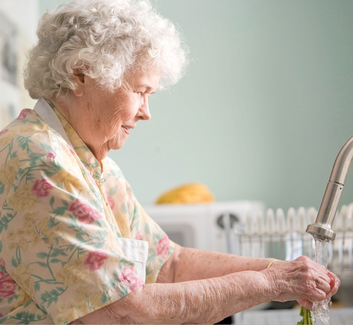 Older woman washing dishes
