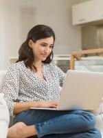 Woman sitting on couch on computer