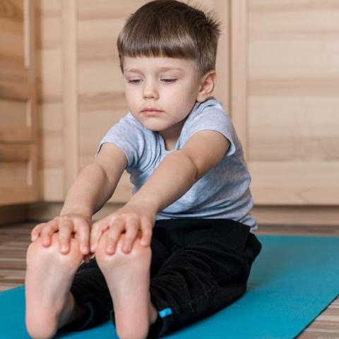 Child stretching on yoga mat