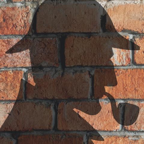 Sherlock Holmes shadow against a brick wall