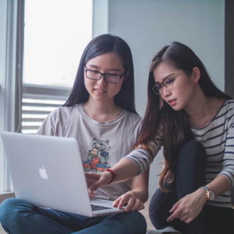 Two teens working on laptop