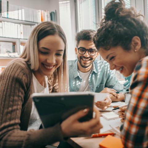 Teens smiling looking at a tablet