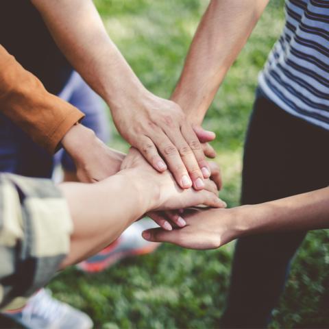 Volunteer hands in a huddle