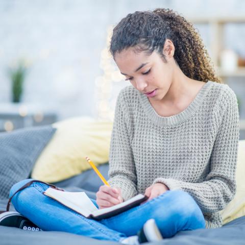 Teen girl writing in journal