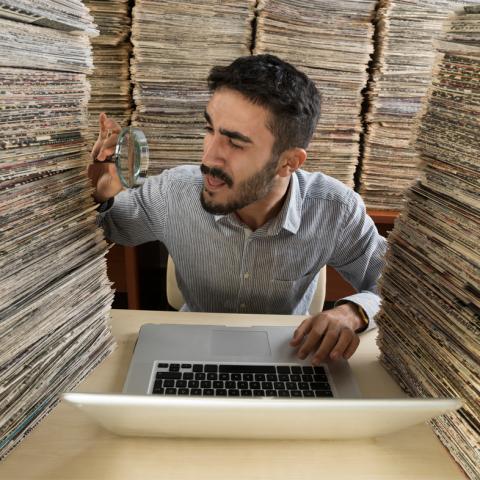 Man searching paper stacks