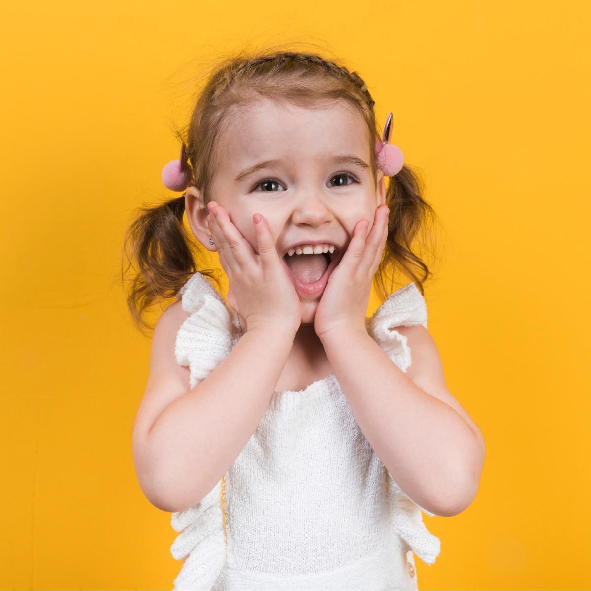 Child surprised with hands on their face