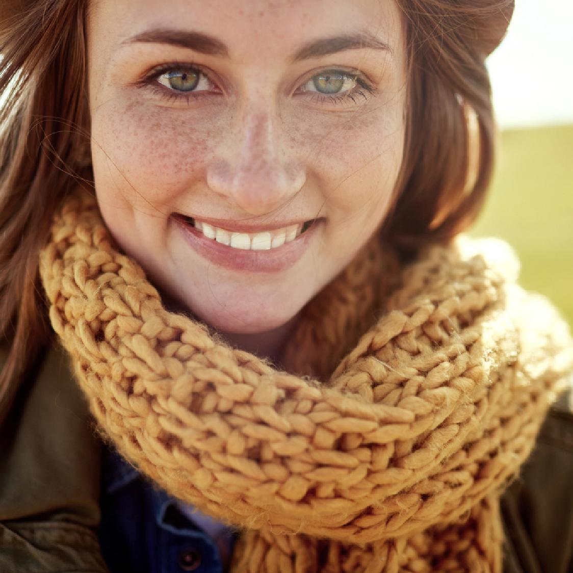 Girl smiling wearing a knit scarf