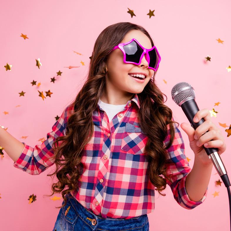 Girl wearing glasses singing into a mic