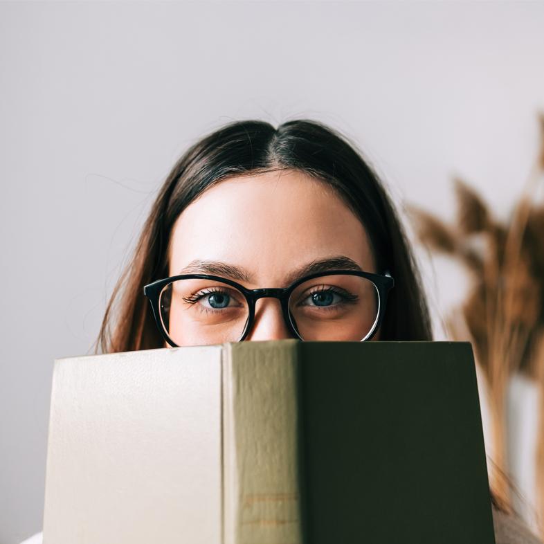 Teen peeking behind book