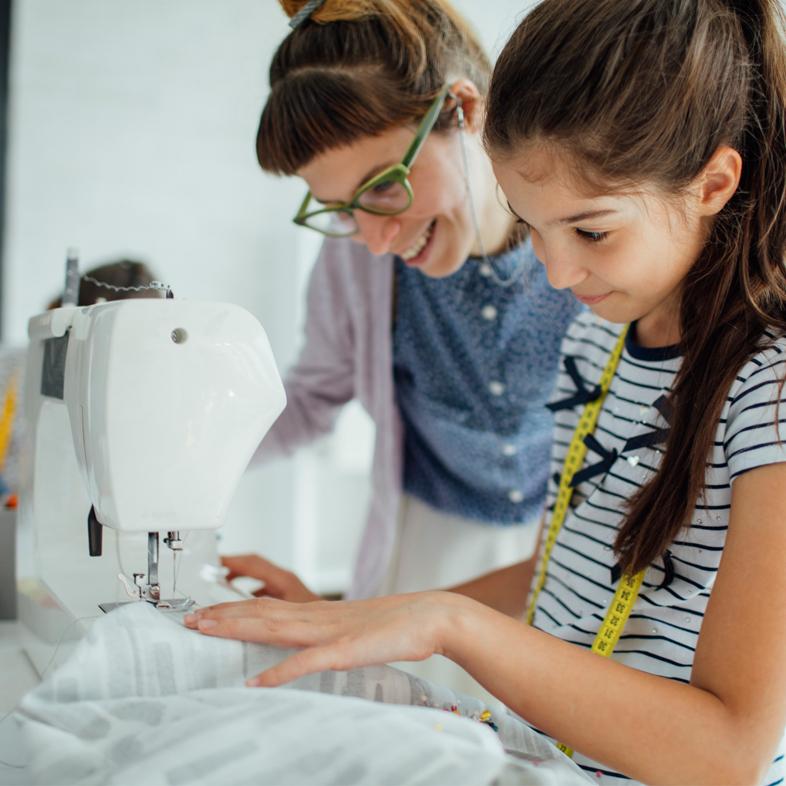 Child learning to sew