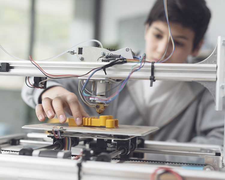 Teen boy using a 3D printer
